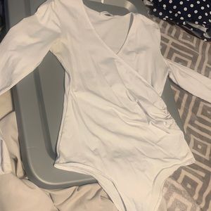 white overlapping body suit. comfy material and form fitting. low cut.